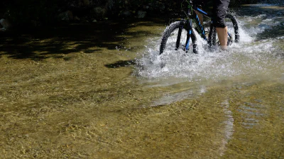 Mountainbiken durch einen Bach — Bewegung für Demokratie